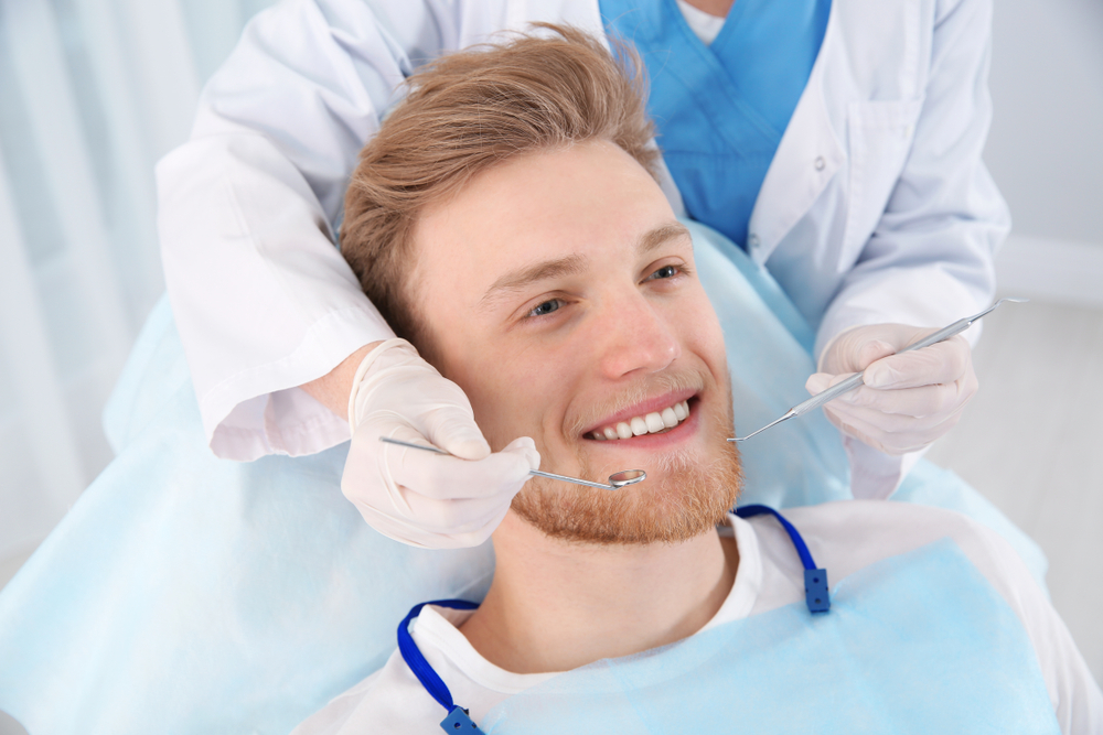 Dentist,Examining,Patient's,Teeth,In,Modern,Clinic
